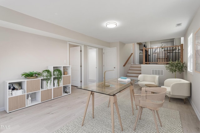 dining space with stairway, baseboards, wood finished floors, and visible vents