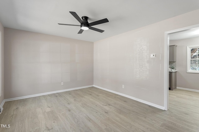unfurnished room with ceiling fan, baseboards, and light wood finished floors