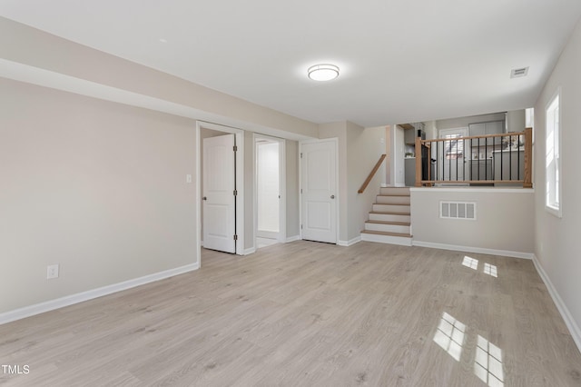 interior space featuring stairs, baseboards, visible vents, and wood finished floors