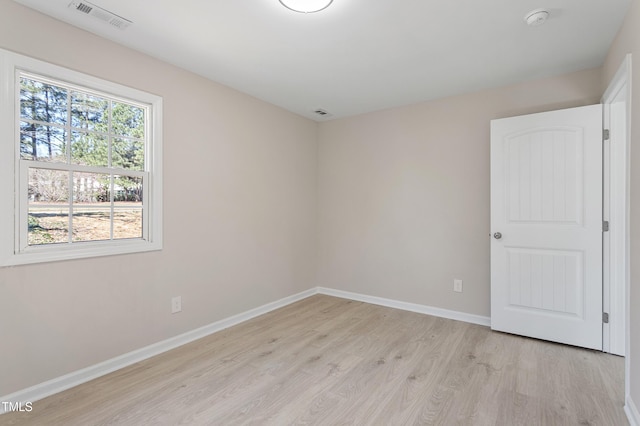 unfurnished room with baseboards, light wood-style flooring, and visible vents