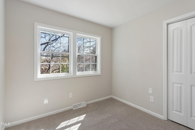 unfurnished bedroom with carpet flooring, baseboards, visible vents, and a closet