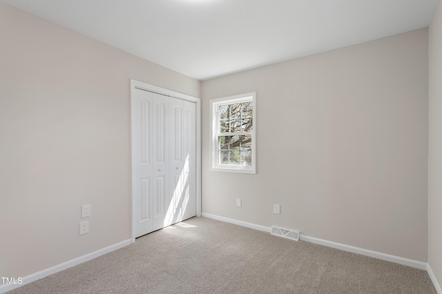 unfurnished bedroom with visible vents, baseboards, and carpet floors