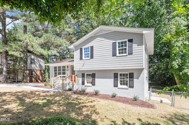 split level home with brick siding and fence