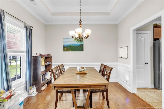 110 Wynngate Dr, Cameron, NC 28326 - dining room with crown molding, a raised ceiling, a chandelier, light wood-style flooring, and a wainscoted wall
