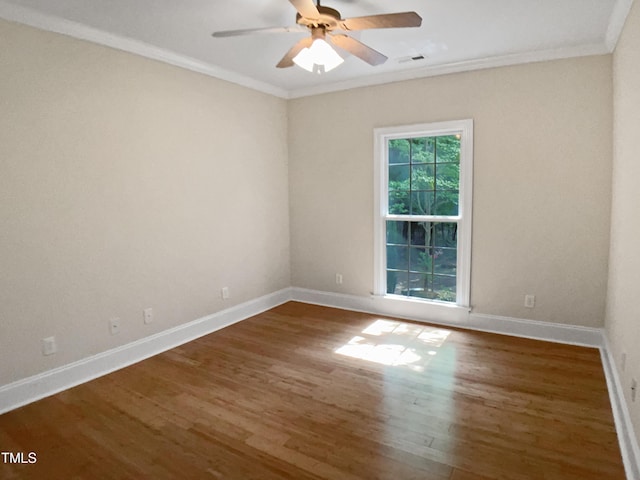 empty room featuring crown molding, visible vents, wood finished floors, baseboards, and a ceiling fan