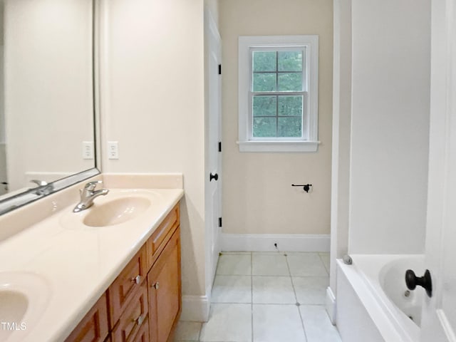 full bath featuring double vanity, a sink, baseboards, and tile patterned floors