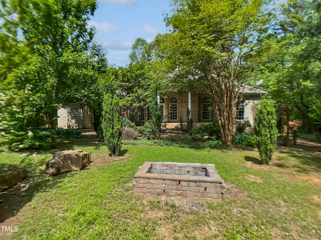 view of yard featuring a porch and an outdoor fire pit