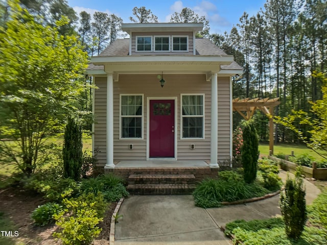 exterior space with a porch and a shingled roof