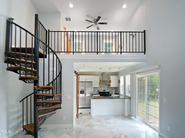interior space with recessed lighting, ceiling fan, and a high ceiling