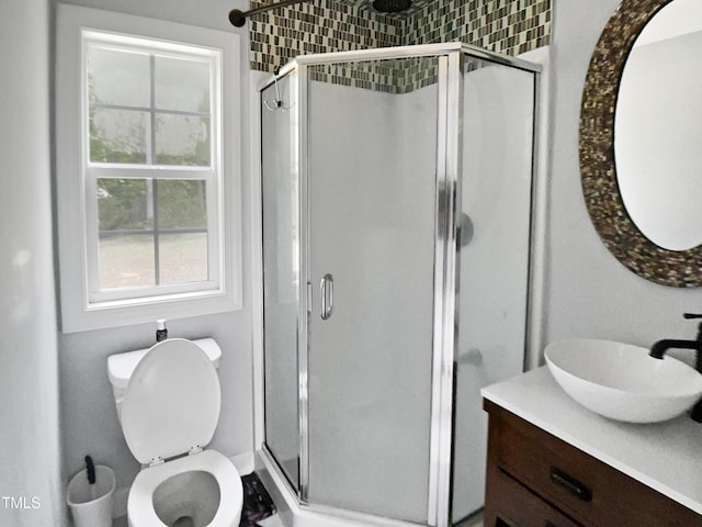 bathroom featuring vanity, toilet, and a shower stall