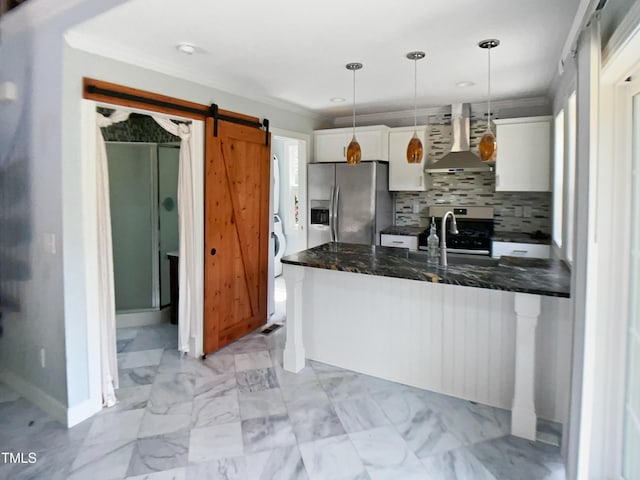 kitchen featuring wall chimney range hood, appliances with stainless steel finishes, a sink, white cabinetry, and decorative backsplash