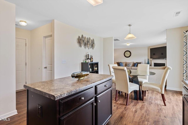 3912 Huntsmoor Ln, Wilson, NC 27896 - kitchen with pendant lighting, dark brown cabinetry, wood finished floors, and visible vents