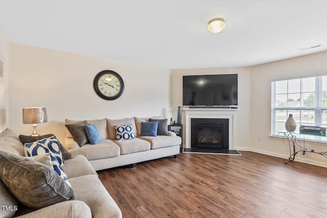 3912 Huntsmoor Ln, Wilson, NC 27896 - living area featuring a glass covered fireplace, baseboards, dark wood-style floors, and visible vents