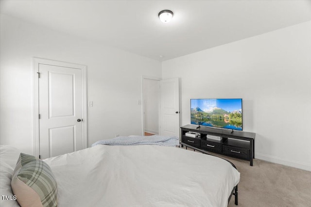 bedroom featuring light colored carpet and baseboards