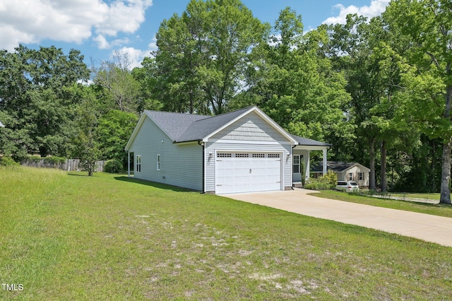 view of side of home with a garage, driveway, and view of wooded area