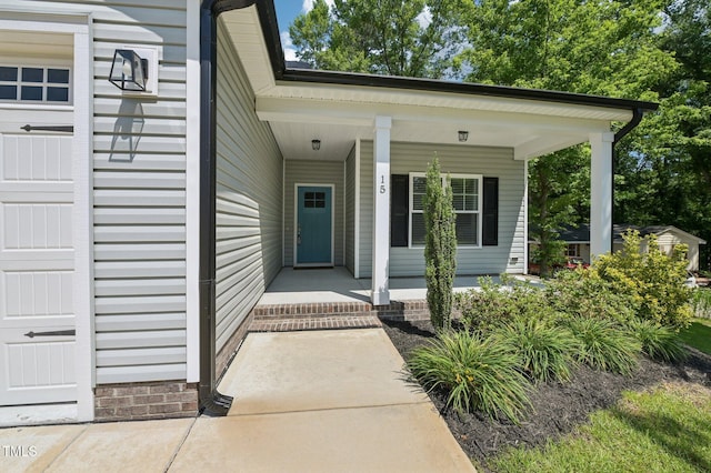 view of exterior entry featuring covered porch