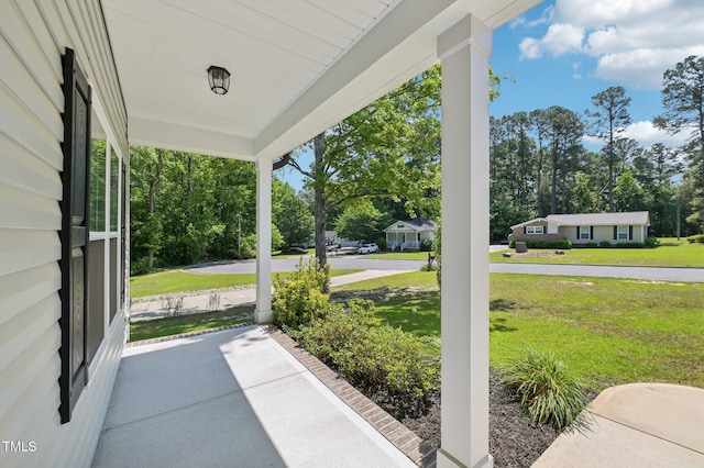 view of patio / terrace with a porch and view of wooded area