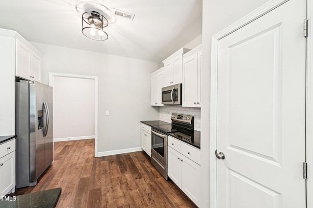 kitchen with appliances with stainless steel finishes, dark countertops, baseboards, and white cabinets