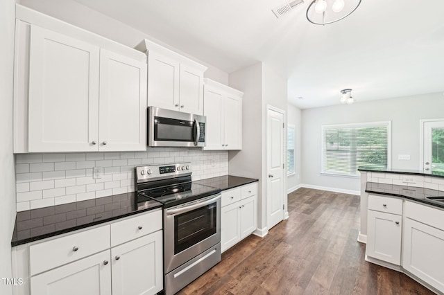 kitchen with appliances with stainless steel finishes, dark countertops, and decorative backsplash