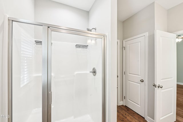 bathroom with a shower stall and wood finished floors