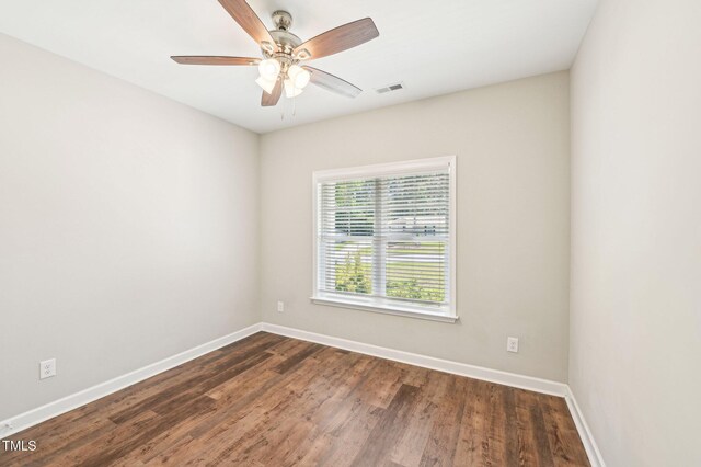 empty room featuring baseboards, dark wood finished floors, and ceiling fan