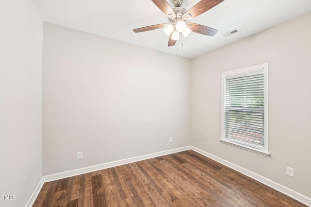 spare room featuring baseboards, dark wood finished floors, and a ceiling fan