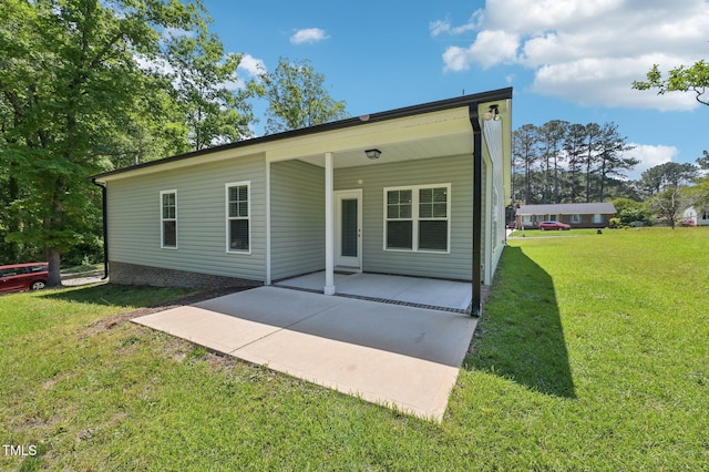back of house featuring a lawn and a patio area