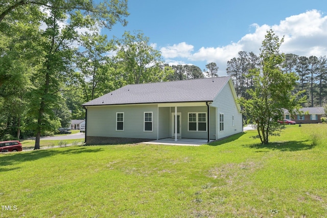 back of house with a patio area and a yard