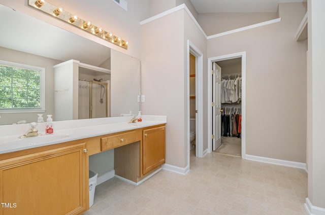 full bathroom featuring vanity, walk in shower, baseboards, toilet, and a spacious closet