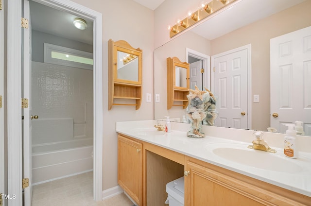 bathroom with double vanity and baseboards