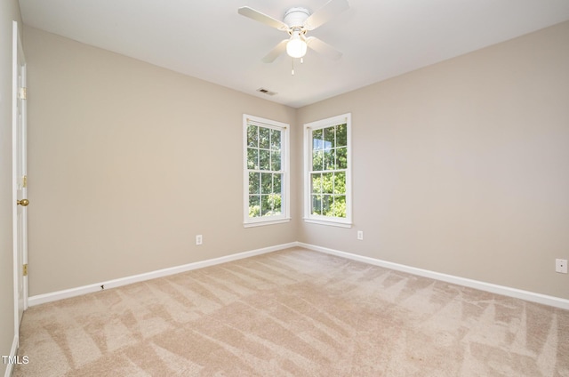 empty room with baseboards, light colored carpet, and ceiling fan