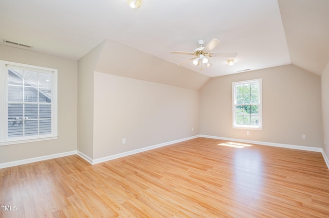 bonus room with light wood finished floors, baseboards, vaulted ceiling, and a ceiling fan