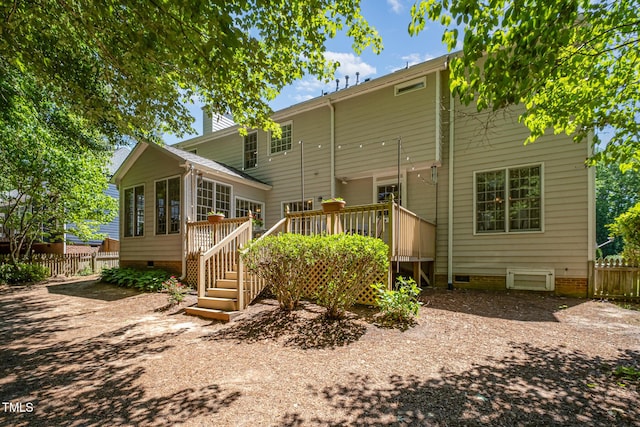 rear view of house featuring crawl space, fence, a wooden deck, stairway, and a chimney