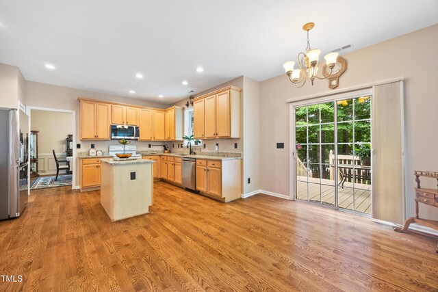 4608 Regency Dr, Durham, NC 27713 - kitchen with appliances with stainless steel finishes, a chandelier, a center island, light brown cabinets, and light wood-style floors