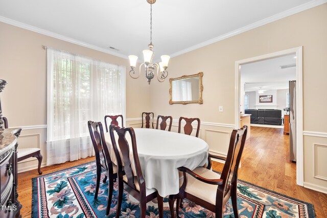 4608 Regency Dr, Durham, NC 27713 - dining area with healthy amount of natural light, crown molding, a chandelier, and wood finished floors
