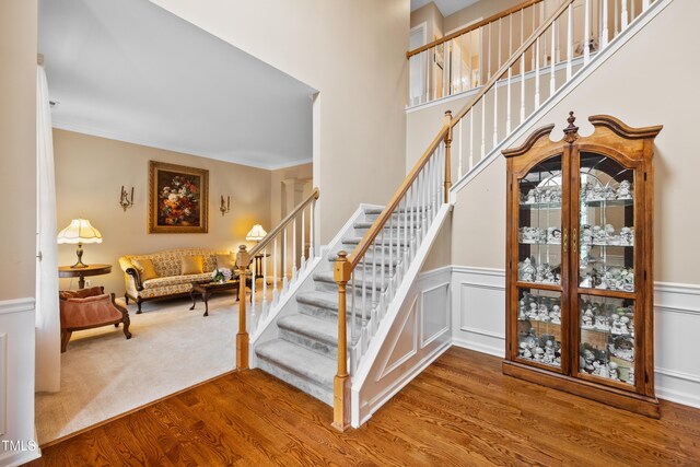 4608 Regency Dr, Durham, NC 27713 - staircase with wood finished floors, wainscoting, and ornamental molding