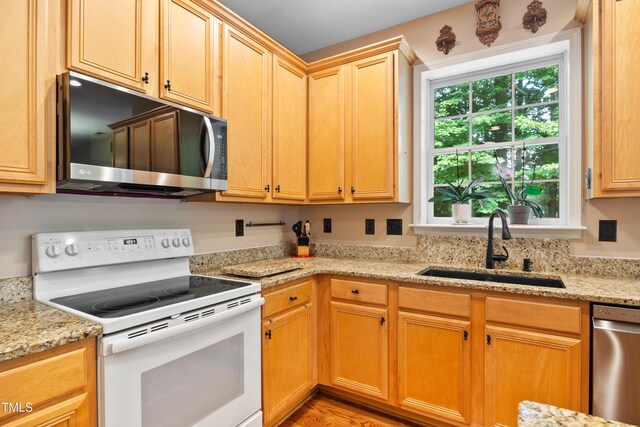4608 Regency Dr, Durham, NC 27713 - kitchen featuring appliances with stainless steel finishes, a sink, and light stone countertops