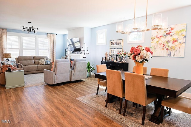 dining area featuring a chandelier, a wealth of natural light, and wood finished floors