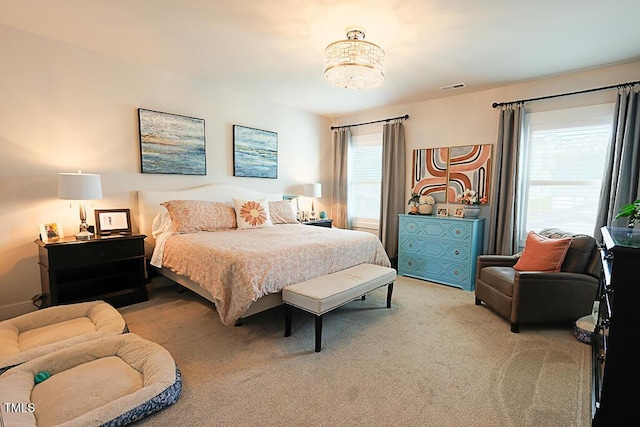 bedroom featuring carpet floors, visible vents, and an inviting chandelier