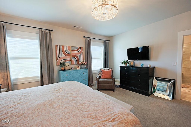 carpeted bedroom with a chandelier and visible vents
