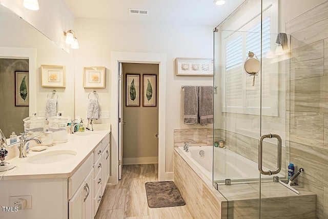 bathroom with a sink, double vanity, a stall shower, and a bath