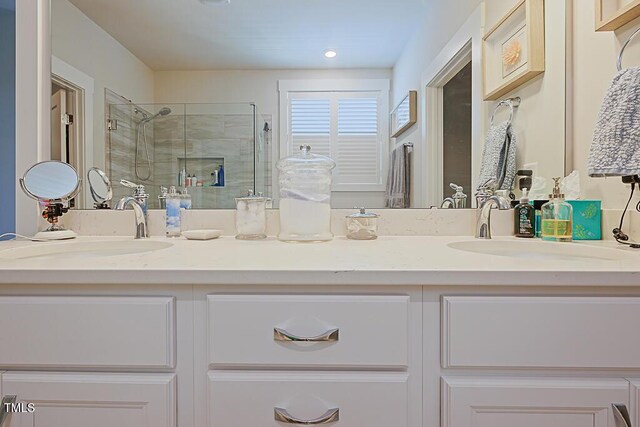 full bath featuring double vanity, a sink, a stall shower, and recessed lighting