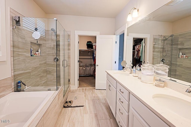 full bathroom featuring double vanity, a sink, a garden tub, and a stall shower