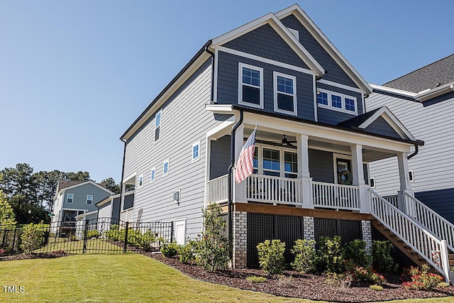 view of front of property with a front lawn, ceiling fan, fence, a porch, and stairway