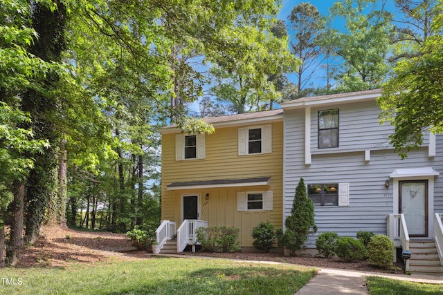 multi unit property featuring board and batten siding and a front yard