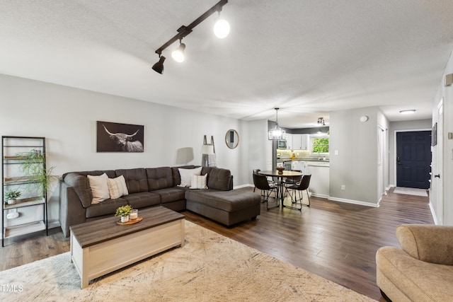 living room with baseboards, dark wood finished floors, and a textured ceiling