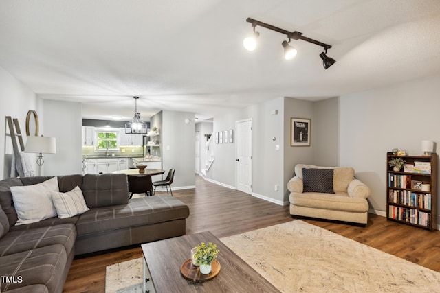 living area with stairway, baseboards, and dark wood-style flooring