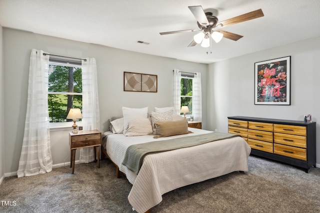 carpeted bedroom featuring baseboards, ceiling fan, and visible vents