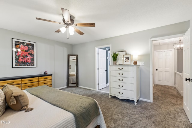 bedroom with carpet floors, baseboards, and ceiling fan with notable chandelier