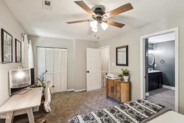 carpeted bedroom featuring ceiling fan, a sink, baseboards, visible vents, and a closet
